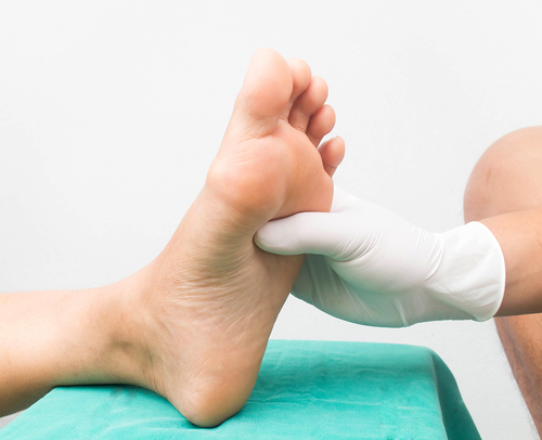 Podiatrist pressing the sole of feet (Zoomed in on the feet and hands) no faces can be seen